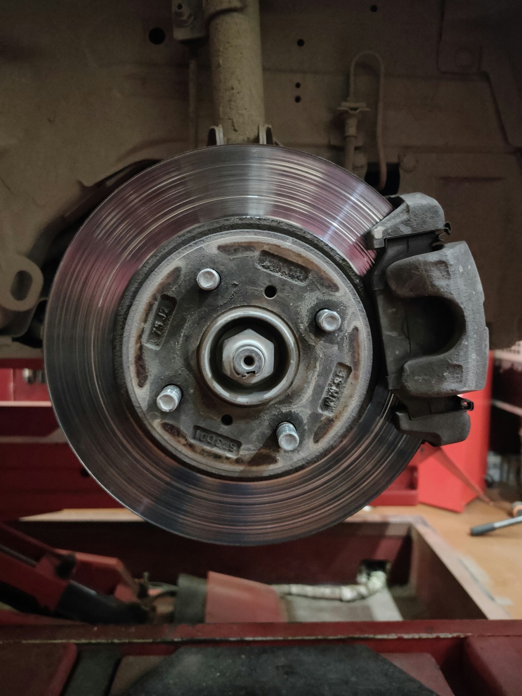 A brake disc and caliper behind a removed wheel