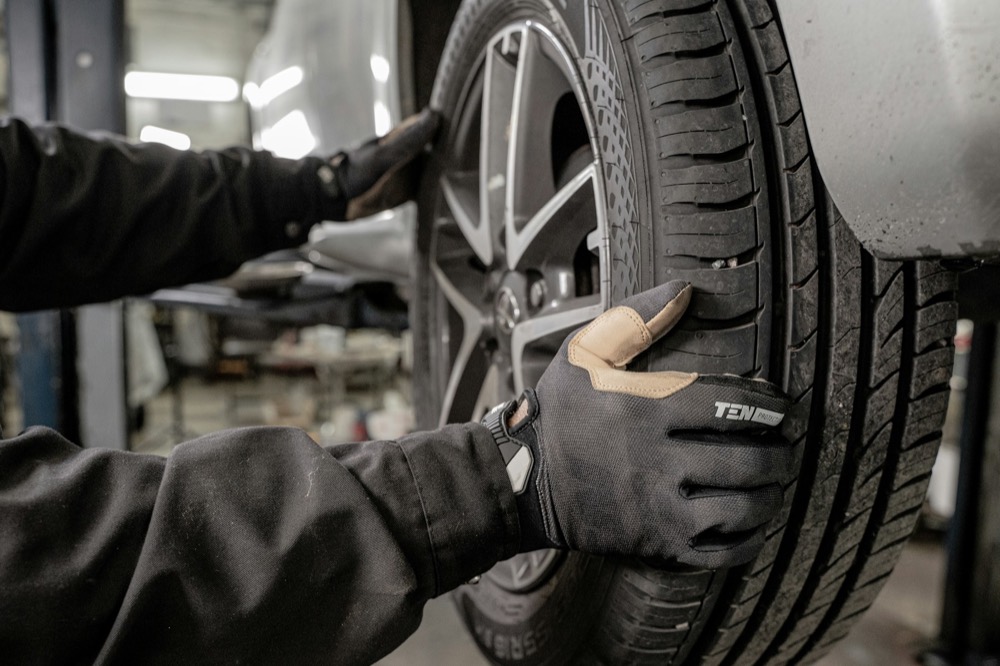 A technician fitting a wheel on a car